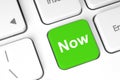 Green button with Now word on the keyboard, abstract concept Royalty Free Stock Photo