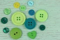 Green buttons haberdashery on a green wooden background