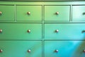 Green cabinet with various drawers, colorful wooden closet close-up retro design background texture