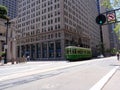 A green cable car and a biker on Market Street, one of the main thoroughfares in San Francisco