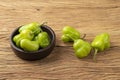 Green cambuci pepper, brazilian cuisine ingredient, on a bowl over wooden table