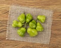 Green cambuci peppers on a rustic fabric over wooden table. Typical brazilian ingredient