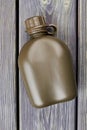 Green camping bottle on wood.