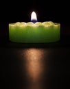 Green candle on a dark background