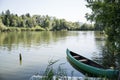 Green canoe boat parked by a lake shore Royalty Free Stock Photo