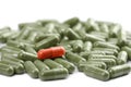 Green capsule pills with red one isolated