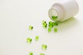 Green capsules on a teaspoon isolated on white background Royalty Free Stock Photo