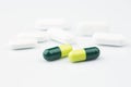 Green capsules and white antibiotic pills. Royalty Free Stock Photo