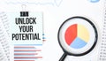 Green card on the white notepad and magnifier on the financial documentation. Text Unlock Your Potential. Business concept Royalty Free Stock Photo