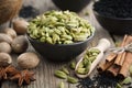 Green cardamom pods in black ceramic bowl. Aromatic spices. Ingredients for healthy cooking. Ayurvedic treatments