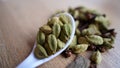 Green cardamom pods on rustic wooden background. Indian spices macro view. elaichi Elettaria cardamomum