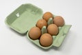 A green carton containing half a dozen eggs