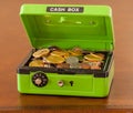 Green cash box with gold and silver coins Royalty Free Stock Photo