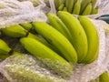 Green Cavendish banana in plastic packing for sale in the market