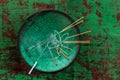 Green ceramic Asian Bowl with needles for acupuncture on an old green paint wooden background Royalty Free Stock Photo