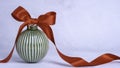 Green Ceramic Christmas bauble with red ribbon bow. Royalty Free Stock Photo