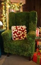 A green chair decorated with moss and a pillow of white and red roses Royalty Free Stock Photo