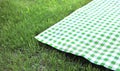 Green checkered cloth on grass empty space advertisement design. Food promotion. Picnic towel flat lay Royalty Free Stock Photo