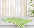 Green checkered kitchen towel on table over defocused curtain background Royalty Free Stock Photo