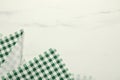 Green checkered tablecloth on white marble background, top view. Space for text Royalty Free Stock Photo