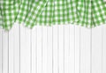 Green checkered tablecloth on wooden table, top view