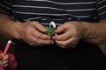 Green children`s safe scissors in the hands of an old man. next to the little baby handles hold a pink felt-tip pen. Grandfather Royalty Free Stock Photo