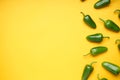 Green chili pepper. Group of jalapeno peppers on a yellow background, place for text, top view Royalty Free Stock Photo