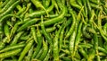 Green chillies background with selective focus on sale in a night market.