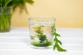 Green Chlorophyll drink in glass with water on white table, Orange Background. Green Drops in clear water, Antioxidant Royalty Free Stock Photo