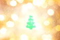 Green christma tree outline on yellow, gold, and white color bokeh background.