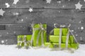 Green christmas background on grey wooden background with snow.