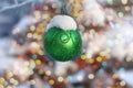 Green Christmas ball hanging on a Christmas tree