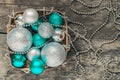 green Christmas balls and silver, beads lie in a wooden basket t Royalty Free Stock Photo