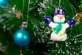 Green Christmas tree with bright colored glass balls and snowman. Royalty Free Stock Photo