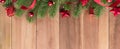 Green Christmas tree leaves with shiny red ornaments on wood bacground Royalty Free Stock Photo