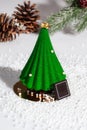 Green Christmas tree shaped cake with fir branch and cones