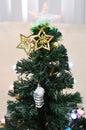 A green Christmas tree with a transparent star topper and other ornaments Royalty Free Stock Photo