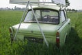 Green classic car in cornfield