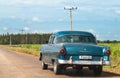 A green classic car driver on the street in the inland