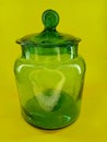 green classic glass jar with yellow backgroun