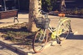 Green classic modern bicycle with basket on the sunset