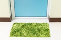 Green cleaning feet doormat or carpet in front of toilet door Royalty Free Stock Photo