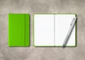 Green closed and open lined notebooks with a pen on concrete background