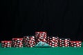 On a green cloth of a gaming table, a set of chips for playing in a casino and two aces, on a black background Royalty Free Stock Photo