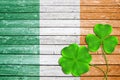 Green clover leaves or shamrocks on wooden background in the color of Irish flag. Royalty Free Stock Photo