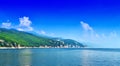 A green coastline in the calm sea in warm summer day. Wonderful romantic landscape panorama