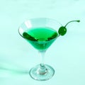 Green cocktail with maraschino cherry in martini glass Royalty Free Stock Photo