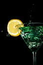 Green cocktail water drink splash in the glass with lemon Isolated on black Royalty Free Stock Photo