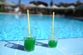 Green cocktails on the background of the pool