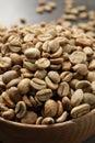 Green coffee beans in wooden bowl on table, closeup Royalty Free Stock Photo